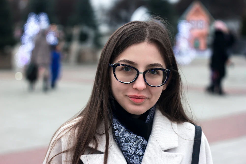 Mujer con abrigo café usando gafas de montura negra